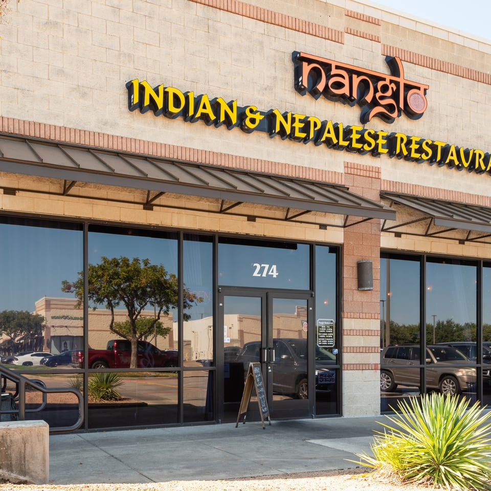 Exterior storefront of Nanglo Indian and Nepalese Restaurant, featuring signage, glass doors, awnings, and address 274.